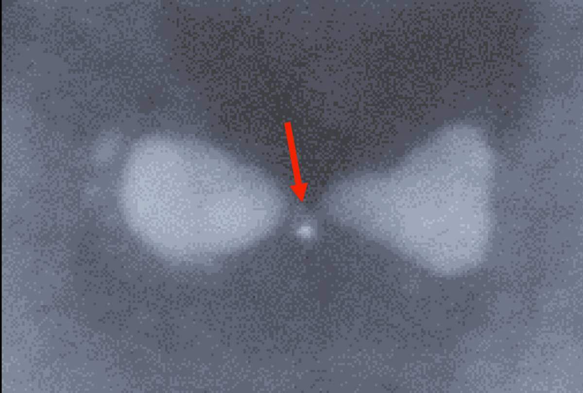A bowtie-shaped nanoparticle made of silver with a trapped semiconductor quantum dot (indicated by the red arrow)