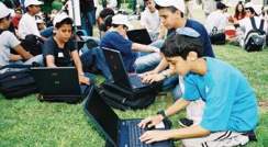 students with Laptops on the grass taking part in learning workshops , at the at the Weizmann Institute
